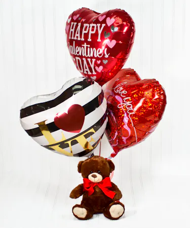 Balloons tied to a teddy bear