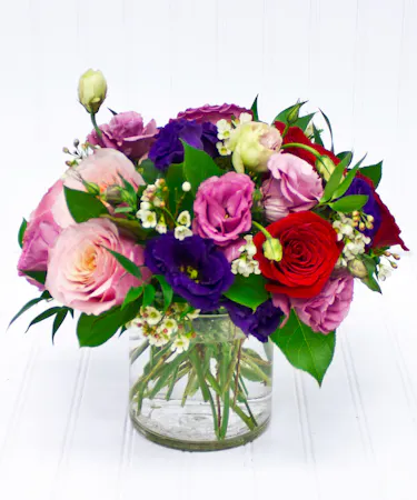 Pink, Purple, Red Roses & Lisianthus is Clear Glass Cylinder
