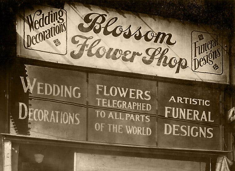 The street sign above our original location boasts of wedding decorations and telegraphed flowers